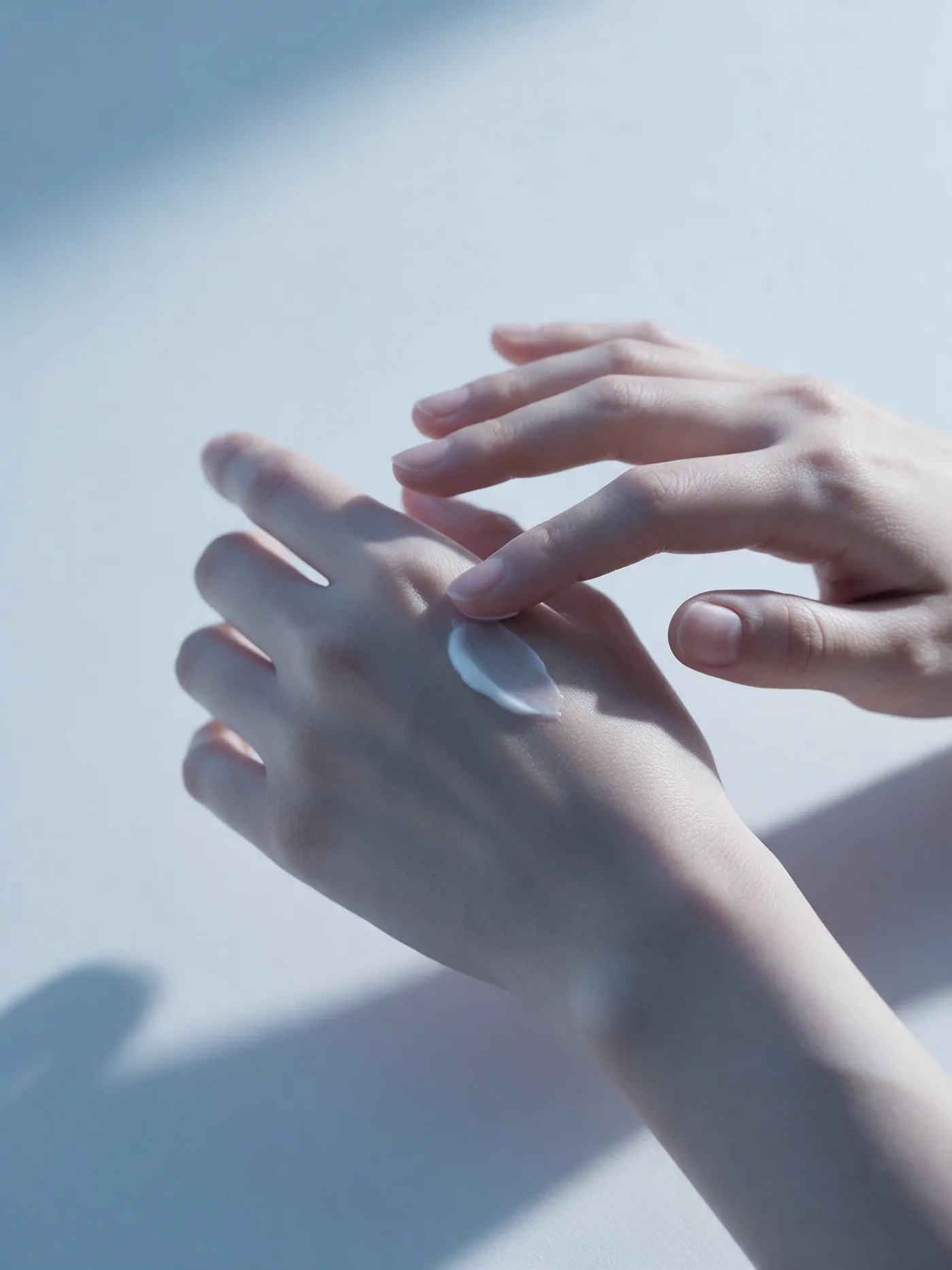 Un polpastrello stende una piccola quantità di crema sul dorso della mano